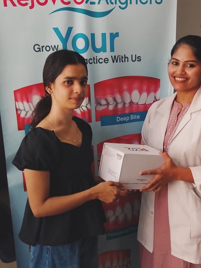 Young woman patient receiving Rejové32 clear aligners with smiling doctor at Glodent